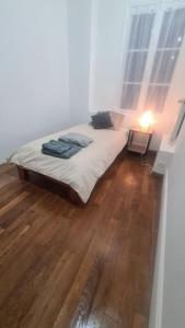 a bedroom with a bed and a wooden floor at Duplex de Prestige in Troyes