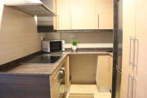 eine kleine Küche mit einer Spüle und einer Mikrowelle in der Unterkunft Apartamento Solêa in Tarragona