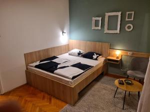 um quarto com uma cama grande e uma mesa em Kineski zid em Zenica