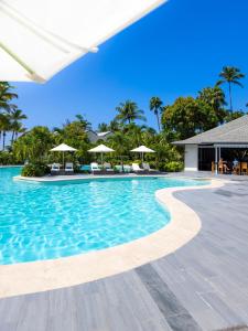 a swimming pool at a resort with chairs and umbrellas at Carlisle Bay in Old Road