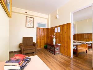 uma sala de estar com uma cadeira e uma mesa em Augusta Villa em Darjeeling