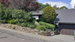 a house with a retaining wall and a garage at Ferienhaus Province in Oberemmel