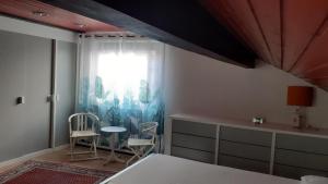 a bedroom with a bed and two chairs and a window at Ferienhaus Province in Konz-Oberemmel +6 photos