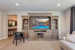 a living room with a large entertainment center with a tv at 96 PV Luxury Getaway with Private Hot Tub, Ping Pong, Community Pool, Water Park and Lazy River in Santa Clara