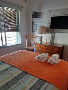 1 dormitorio con 2 toallas en una cama en Casita Deìa en San Pedro