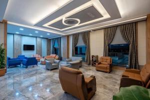 a lobby with couches and chairs and a fireplace at Afyon Regulus Thermal Apart Hotel & Villas in Gazligol
