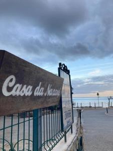 a sign on a fence next to the beach at Casa da Nazaré in Portinho da Arrábida