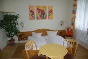 a bedroom with a bed and a table with chairs at Landgasthof Heerlein in Bamberg