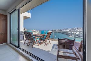 a balcony with a table and chairs and a view of the water at Gorgeous two bedroom sea view in Marsascala in Marsaskala
