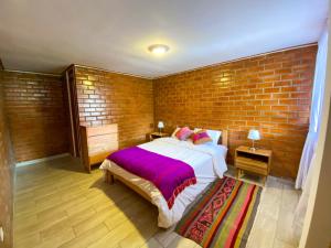 a bedroom with a bed and a brick wall at Tupac Huaraz in Huaraz +53 photos