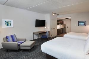 a hotel room with a bed and a chair and a desk at TownePlace Suites by Marriott Hamilton in Hamilton