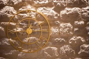 um relógio de ouro no lado de uma parede de pedra em Luxury Apartments Lilly 2 em Split