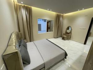 1 dormitorio con cama, ventana y silla en سحاب تهلل السودة Sahab AL-Sodah, en Sawda