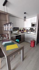 uma cozinha com uma mesa de madeira e uma cozinha com armários brancos em Hermoso Departamento con vista al Mar em Viña del Mar