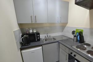 a small kitchen with a sink and a microwave at Victoria Bay - Whole Apt - 2 Bed - WiFi - Beach - Harbour - Herne Bay in Herne Bay