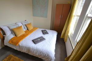 a bedroom with a bed with an orange blanket and a window at Victoria Bay - Whole Apt - 2 Bed - WiFi - Beach - Harbour - Herne Bay in Herne Bay