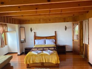 1 dormitorio con cama y techo de madera en Posada Quetzalin, en Cuetzalán del Progreso