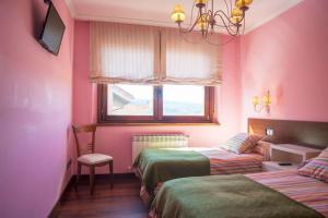 Habitación rosa con 2 camas y ventana en Casa Rural San Lorenzo, en Covaleda