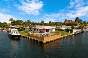 a dock with a house and a boat on the water at LOCATION LOCATION LOCATION in Pompano Beach