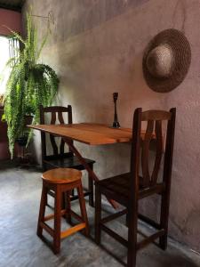 a wooden table and two chairs and a table and a plant at Casa di Vó in Mucugê