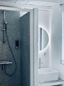 ein Bad mit einer Dusche und einem Waschbecken in der Unterkunft CASA AZUL - jardin, calme, tennis in Nîmes