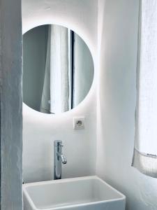 uma casa de banho branca com um lavatório e um espelho em CASA AZUL - jardin, calme, tennis em Nîmes