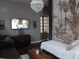 ein Wohnzimmer mit einem Flachbild-TV an der Wand in der Unterkunft Cozy Apartment in Altenbrak
