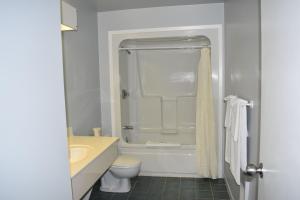 ein Badezimmer mit einer Badewanne, einem WC und einem Waschbecken in der Unterkunft Dundee Resort & Golf Club in West Bay