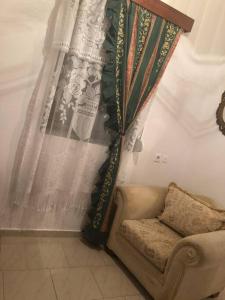 uma cortina no canto de um quarto com um sofá em Traditional house kalavarda Rhodes em Kalavárda