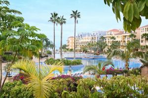 a view of a resort pool with palm trees and plants at Bahia Principe Sunlight Tenerife in Adeje