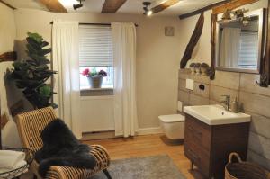 a bathroom with a sink and a toilet and a window at Hofgarten Rosa in Ilbesheim