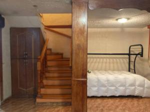 a bedroom with a bed and a staircase with a stair case at 7 camas 1 sofá cama, 20min Airport in Mexico City