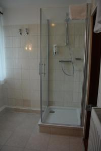 a bathroom with a shower with a glass door at Hotel Oyten am Markt in Oyten