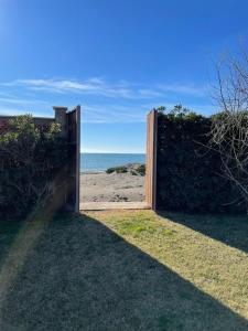 Una puerta a la playa con el océano detrás. en Ferienhaus in Voltone mit Großem Garten, en Porto Clementino
