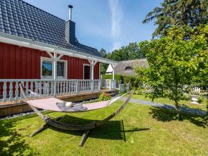 a hammock in front of a red house at Ferienwohnung Ostseestrand Zingst in Zingst