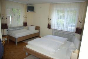 a room with two beds and a tv and two windows at Landgasthof Heerlein in Bamberg +18 photos