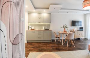 eine Küche und ein Esszimmer mit einem Tisch und Stühlen in der Unterkunft Apartamenty na Wyspie - Villa Park - Parking in Świnoujście