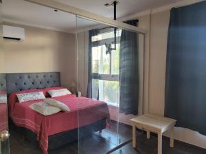 a bedroom with a red bed and a window at Depto. Céntrico III in Corrientes