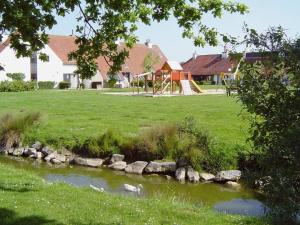 a park with a pond and a playground with at Ysermonde Fisherman's Cottage in Nieuwpoort