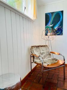uma cadeira num quarto com um quadro na parede em Casa Korallen em Varberg