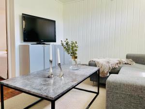 a living room with a table with two candles and a tv at Casa Korallen in Varberg
