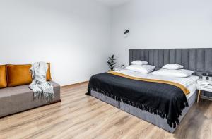 una camera con un grande letto e un divano di BeeApartments Długosza 11 a Nowy Sącz