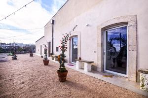 um edifício com vasos de plantas ao lado em Masseria Casino Ciomme em Gioia del Colle