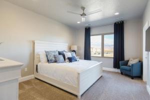 a bedroom with a white bed and a blue chair at Zion Village Resort 2102 Community Pool, Ping Pong table, and near Zion National Park in Hurricane +92 photos