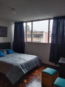 1 dormitorio con cama y ventana grande en Habitaciones Centro Histórico, en Bogotá