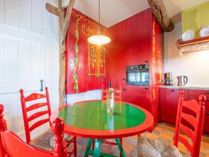 een rode keuken met een groene tafel en rode muren bij Farmhouse in Staphorst with sauna in Rouveen