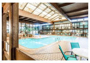 a large indoor pool with a table and chairs at Altoona Grand Hotel in Altoona