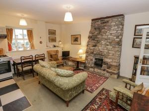 a living room with a large stone fireplace at Longlands Groom's Quarters in Cartmel
