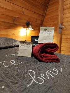 ein Bett mit einem roten Schal und zwei Schildern darauf. in der Unterkunft Choco B&B in Telese