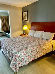 a bedroom with a large bed with a floral bedspread at American Way Inn & Suites in Memphis